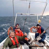Day Skipper-A day on the Indian Ocean and a crew of Offshore Sailing Academy students are Smiling at the Camera in the background the Durban Skyline