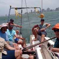 Day skipper-A sunny day on the Indian Ocean and a crew of Offshore Sailing Academy students are Smiling at the Camera in the background the Durban Skyline
