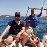 Combo Course-A sunny day on the Indian Ocean and a crew of Offshore Sailing Academy students are Smiling at the Camera in the background the Durban Skyline
