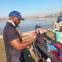Intro to Sailing: A group of enthusiastic beginners learning the basics of sailing in the Durban Sailing school on a sunny day. Smiles all around.